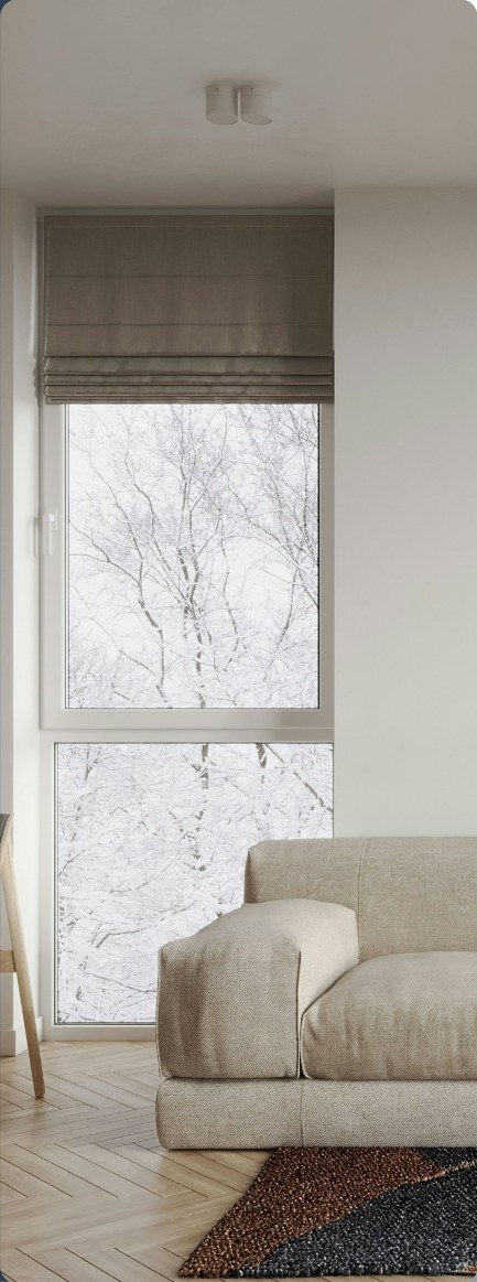 A linen sofa below a window looking out on snowy trees